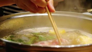 People eating sukiyaki in pot video