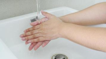 Conjunto de senhora lavando as mãos em banheiro branco video