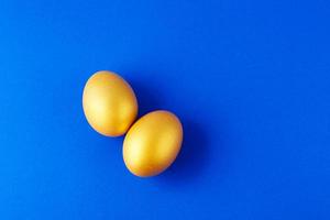 Gold eggs on blue background photo