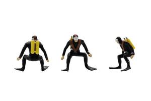 Miniature figurines of scuba divers isolated on white background photo