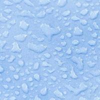Gotas de agua macro sobre la superficie azul foto