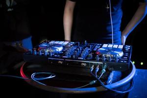 DJ playing turntable music at night club photo