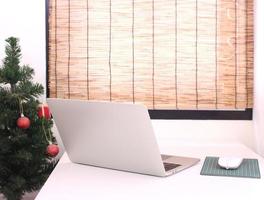 Workspace with laptop and Christmas tree photo