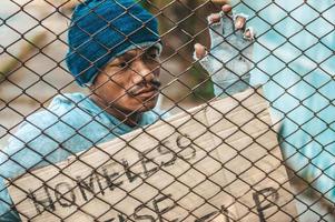 Beggars at a fence with homeless messages please help photo