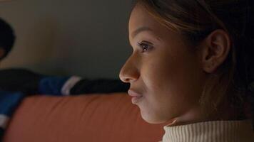 Close-up of black young woman watching television, laughing and talking with Asian young man video