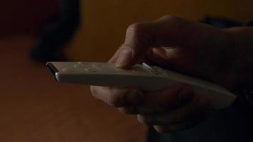 Close-up of remote control, touched by hand of Asian young man. video