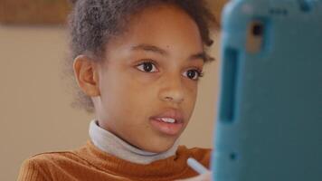 Close up of girl, tablet in front of her, moving with stylus pen, eyes focused on tablet, touches her face shortly and talks video