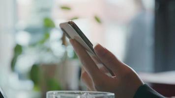 cellulare tenuto in mano di giovane donna nera, parlando, sorridendo e scrivendo con l'altra mano video