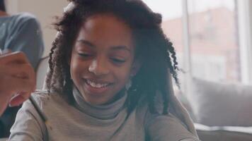 Close up of girl, smiling, holding pencil in hand, looking down, close up of hand of man taking over pencil, close up of man, eyes on pencil, girl watches video