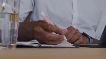 Close up of hands of mature man, paging in notebook and writing in it with pen video