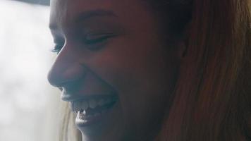 la giovane donna nera parla e sorride, mentre guarda lo schermo del laptop - non mostrato video