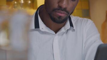 Head of mature man looks up to the right - camera, turns head, eyes on his writing in notebook in front of him video