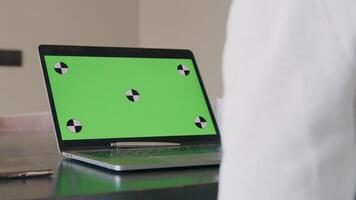 geopende laptop, met groen scherm en pen op toetsenbord, wazig arm video