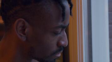 Close up of mature black man, looking through the window whilst putting on face mask and adjusting it video