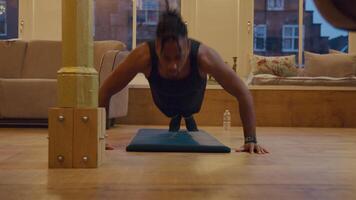 Mature black man doing push ups on mat in the middle of the living room. Camera in front of the man. video