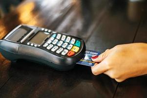 Close-up of woman paying with credit card in cafe photo