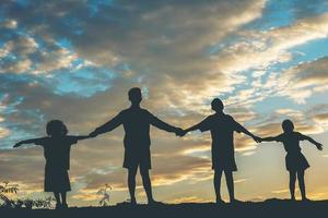 silueta de niños jugando al atardecer foto