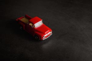 Camioneta modelo pickup roja sobre un piso negro foto
