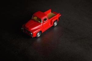 Red pickup model truck on a black floor photo