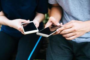 Close-up of friends playing on smartphones together photo