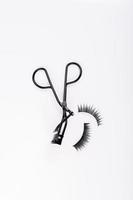 Fake false eyelash with curler isolated on white background photo