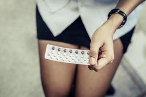 Woman holds birth control pills