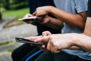 Close-up of friends playing on smartphones together photo