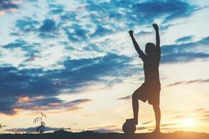 Silhouette of children playing soccer football photo