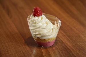 Postre de frambuesa con crema batida en un vaso foto