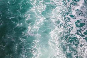 Cerca de burbujas de un ferry en el mar, sendero de barco de agua de mar con una ola espumosa foto