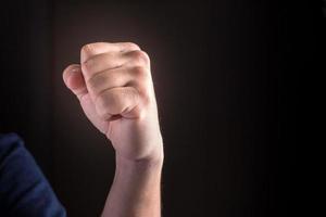 Hand with a clenched fist on a black background