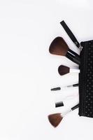 Make-up brushes in cosmetic bag isolated on white background photo