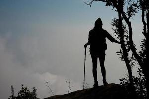 silueta de excursionista en la cima de las montañas foto