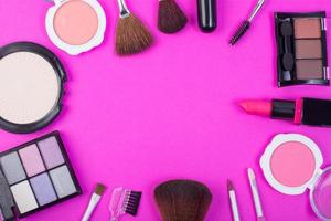 Vista superior de una colección de productos cosméticos de belleza sobre un fondo rosa foto