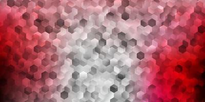 Light pink, red vector backdrop with a batch of hexagons.