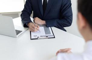 Person filling out forms in white office photo