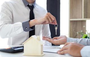 Realtor giving house keys to new owner photo