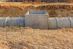 Tubo de drenaje y boca de inspección en un sitio en construcción foto