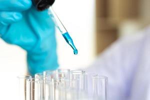 Scientist filling test tubes with dropper photo