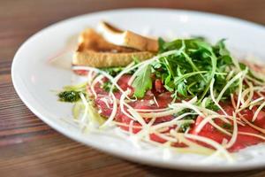 Carpaccio with parmesan cheese on a plate photo