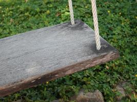 Wood swing against green grass photo