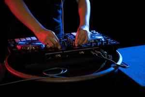 DJ playing turntable music at night club party photo