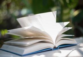 Close-up of open book with nature bokeh background photo