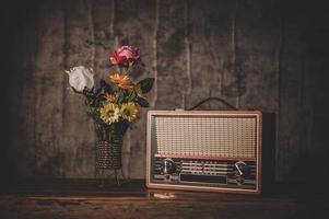 Still life with a retro radio receiver and flower vases photo