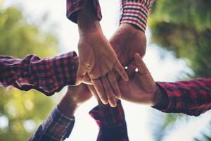 Close-up view of young people putting their hands together photo