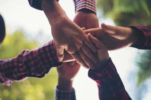 Close-up view of young people putting their hands together photo