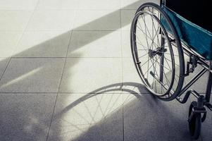 Paciente en silla de ruedas estacionada frente al hospital.