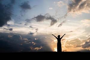 Silhouette of woman standing with sunset photo