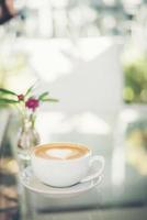 Café latte art con espuma de leche en forma de corazón en la mesa foto
