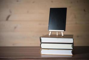 pequeña pizarra y pila de libros foto